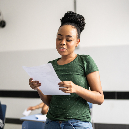 Young woman reading a poem in front of a group 